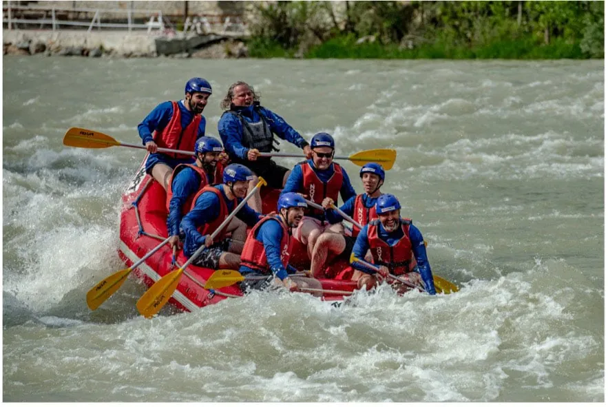 A group of people in a raft boat on a river