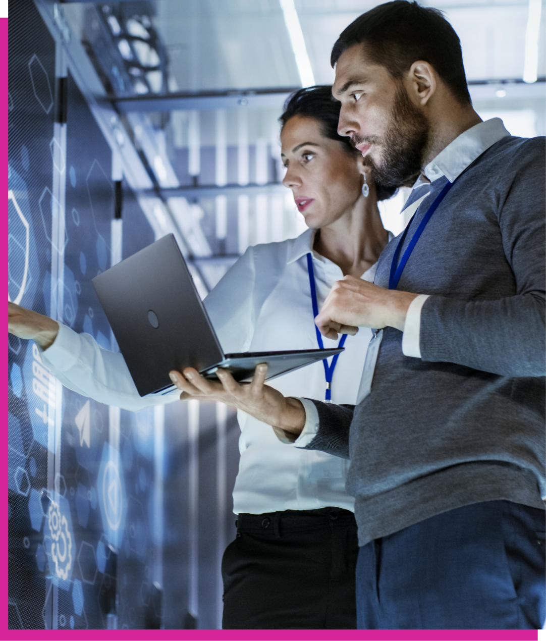 IT professionals standing in a server room with a laptop